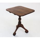 A George III oak tripod table, the rectangular top with rounded corners, raised upon a ring turned