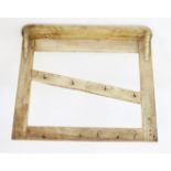 A rustic pine hanging wall rack, with a rectangular shelf above a pair of uprights united by an