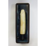 A Japanese carved ivory erotic okimono, modelled as a phallic carving with turned wooden handle to