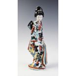 A Japanese Kutani porcelain geisha, 20th century, modelled standing with a cat to her feet, 28cm
