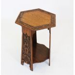 An early 20th century Arts and Crafts oak occasional table, the hexagonal top with a leaf carved