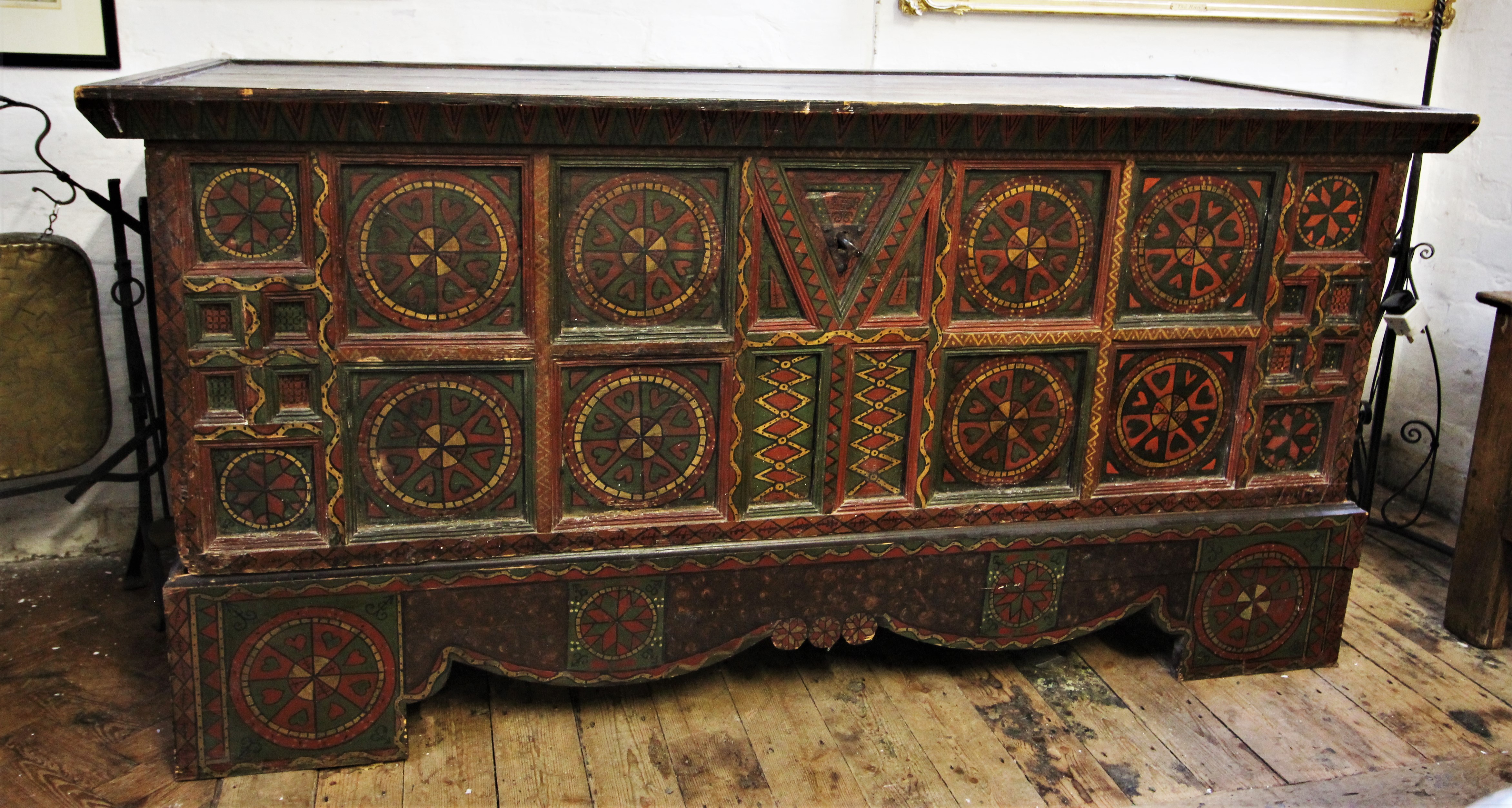 A 19th century Eastern European painted folk art pine chest, painted with geometric designs, the