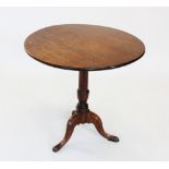 A George III oak tripod table, the circular top raised upon a ring turned tapering column and