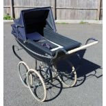 A vintage Silver Cross pram, mid 20th century, the boat shaped body with a folding canopy, raised