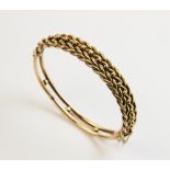 A yellow metal braided bangle, the hinged bangle with woven top section and beaded back, attached