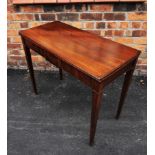 An early 19th century mahogany folding tea table, the frieze inlaid with stringing and raised upon