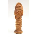 A Tribal figural carving, possibly Dan, Ivory coast, carved as a mask upon a ribbed column in the