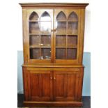 A 19th century honey oak library bookcase, the moulded cornice above a pair of arcaded glazed