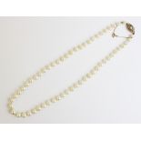 A cultured pearl necklace with a diamond set clasp, designed as a single row of graduating