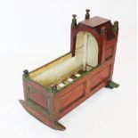 A Victorian painted pine cradle, the angular canopy flanked by turned finials above invert