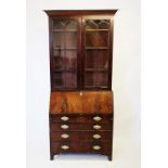 An early 19th century mahogany bureau bookcase, with a moulded tapering cornice above a pair of