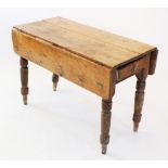 A Victorian pine drop leaf kitchen table, with a single frieze drawer, raised upon turned tapering