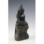 An Indian carved wood and painted model of Buddha, seated in vajrasana and hands held in the