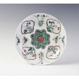 A Chinese porcelain Wucai dish, Kangxi period, of circular form, centrally decorated with a flower
