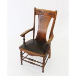 A late 19th century oak country elbow chair, the concave top rail with incised detail above a shaped