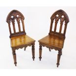 A pair of Puginesque oak hall chairs, late 20th century, each with a Gothic influence open work