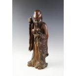 A Chinese carved wood figure of Shou Lao, realistically modelled standing holding two gourds,