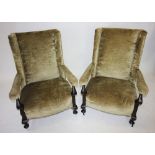 A pair of Edwardian mahogany and upholstered open armchairs, each with a straight back rest, flanked