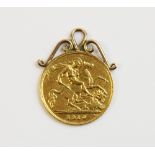 An Edwardian half sovereign, dated 1910, within a yellow metal scrolling pendant mount, gross weight