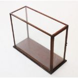 A late 19th / early 20th century mahogany framed display case, the hinged door with brass handle and