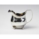 A George III silver cream jug by John Merry, London 1912, of oval baluster form with engraved