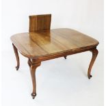 An early 20th century walnut dining table, the rectangular top with rounded corners, raised upon