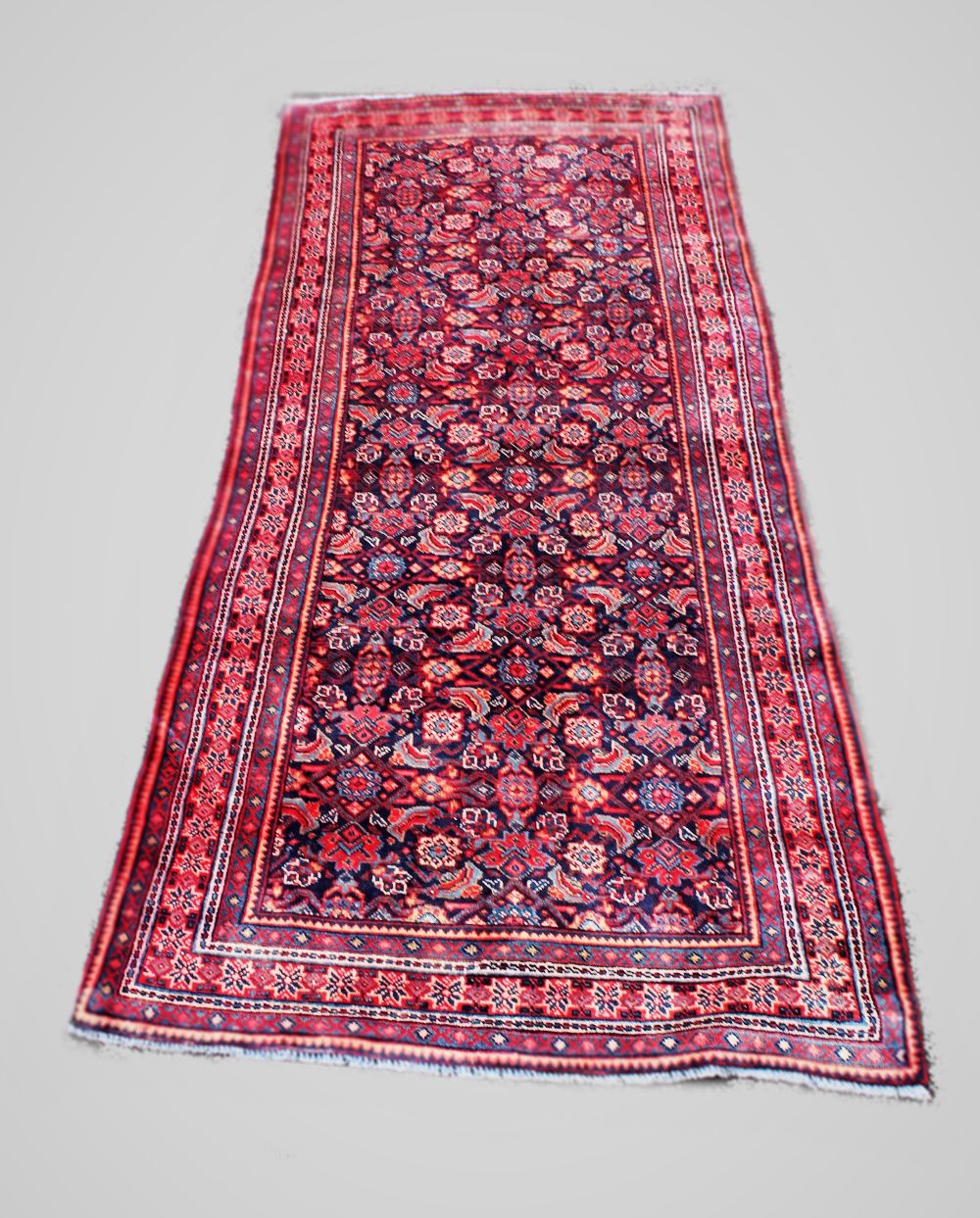 A Persian Saruq runner, with traditional all over design against a blue ground, 279cm x 124cm
