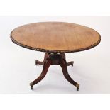 A Regency mahogany centre table, the circular top with gadrooned border, raised upon a ring turned