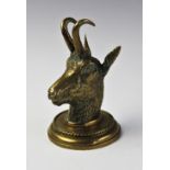 A Victorian novelty brass inkwell modelled as a goats mask, with hinged cover on a circular base,