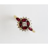 A ruby and diamond 18ct gold cluster ring, comprising a central round brilliant cut diamond weighing