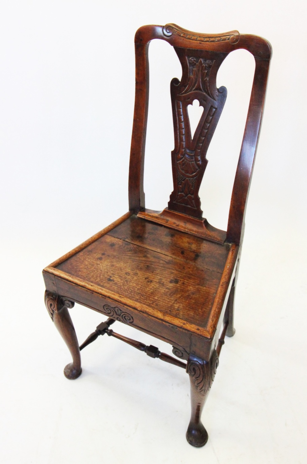 A late 17th century oak side chair, with a pierced and carved vase shaped splat above a board seat