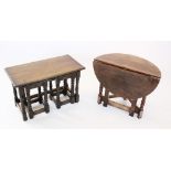 A reproduction oak nest of three tea tables, raised upon turned baluster and block supports united