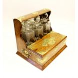 A late Victorian oak Tantalus, of typical form enclosing three decanters and stoppers