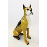 A mid 20th century glazed composite fireside model of a boxer dog, modelled in a seated position