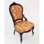 A Victorian walnut ladies chair, the shaped padded back rest with a carved shield shaped crest,