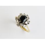 A sapphire and diamond cluster ring, comprising a central oval cut sapphire measuring 7mm x 5mm,