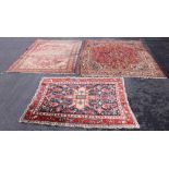 A Caucasian wool rug, the floral design with a central green medallion on a red ground, 205cm x