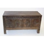 An early 17th century oak coffer, the hinged plank cover carved 'ER 1705', enclosing a fitted candle