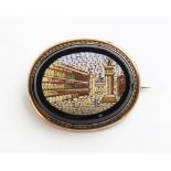 A 19th century micromosaic brooch, depicting a city scene, set to a yellow metal oval border, 49mm x