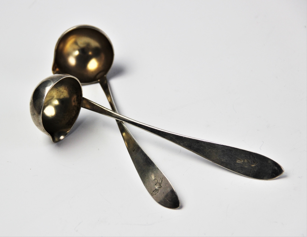 A pair of 19th century continental silver cream ladles, the handles engraved with thistles,
