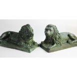 A pair of patinated bronze lion sculptures, 20th century, each modelled recumbent in reflected poses