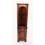 A reproduction freestanding oak corner cabinet, late 20th century, with an arched frieze above two