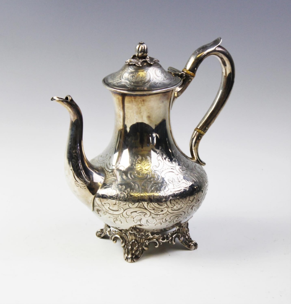 A Victorian silver coffee pot by John Wellby, London 1843, of baluster form on four scrolling