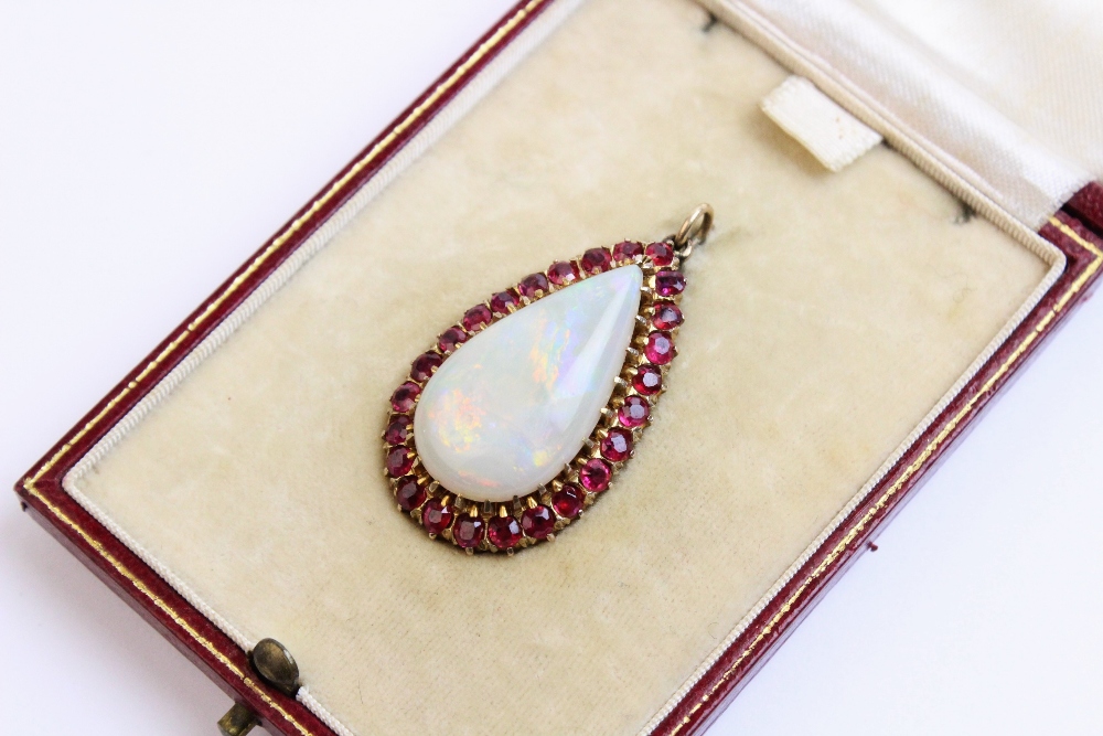 An opal and untested ruby set pendant within a fitted Wartski case, the pear shaped opal