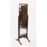 An early 20th century oak cheval mirror, the rectangular mirror with canted top corners, raised upon