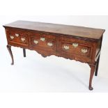 A George III oak and mahogany cross banded dresser base, the rectangular cross banded top with