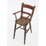 A Victorian child's elm and beech correction chair, the shaped elm seat flanked by turned arms and