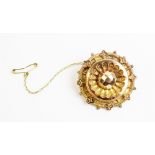 A Victorian 9ct gold Etruscan style target brooch, of circular form with with vacant compartment