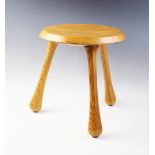 A pine lacquered three legged milking stool, designed by IKEA founder Ingvar Kamprad for the Habitat