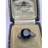 A sapphire and diamond ring, comprising a central octagonal cut blue sapphire weighing approx. 5.6ct
